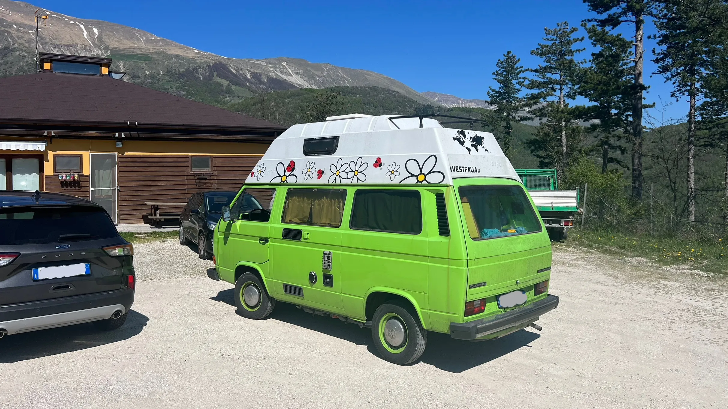 The green Volkswagen T3 parked on a gravel lot
